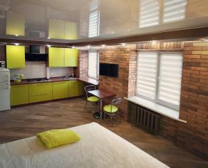 una cocina con armarios verdes, mesa y sillas en Luxury Loft в центре Полтавы, en Poltava