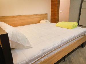a large white bed with a yellow pillow on it at Luxury Loft в центре Полтавы in Poltava