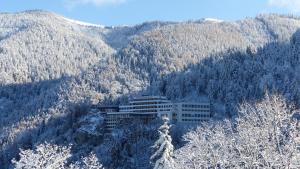 budynek w środku pokrytej śniegiem góry w obiekcie Sporthotel am Semmering w mieście Semmering