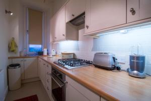 a kitchen with a counter top with a stove top oven at West Highland Apartments Milngavie - The Nevis in Milngavie