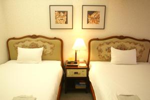 Postel nebo postele na pokoji v ubytování Ryukyu Sun Royal Hotel