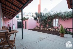 a patio with a table and chairs and a pink building at Alfama Dream Apartments in Lisbon