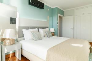 a bedroom with a white bed and a blue wall at Vila Formosa I by An Island Apart in Funchal +26 photos
