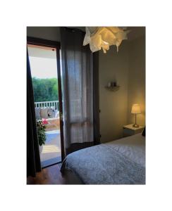 sypialnia z łóżkiem i przesuwnymi szklanymi drzwiami w obiekcie Villa Rosa Charming Flat w mieście Su Forti