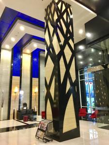 a lobby with a pillar in the middle of a building at Cozy and Bright - Trillium Downtown Surabaya in Surabaya