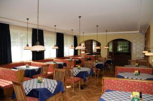 a restaurant with tables and chairs with blue and white tablecloths at Strandhotel in Weyregg