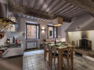 una cucina con tavolo e sedie in una stanza di Apartment La Scala 1572 a San Quirico dʼOrcia