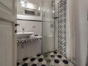 a small bathroom with a sink and a shower at Apartment La Scala 1572 in San Quirico dʼOrcia