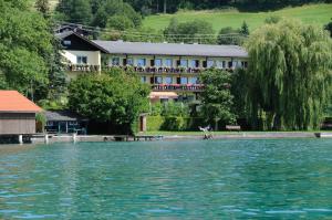 a large body of water with a building in the background at Strandhotel in Weyregg