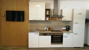 a kitchen with white cabinets and a sink at Haus Wildschütz in Hippach