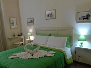 トラーパニにあるBilocale al Centroのベッドルーム1室(緑のベッド1台、白鳥2頭付)
