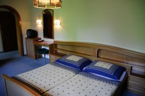 فندق ستراند في ويرغ: غرفة نوم مع سرير ووسائد زرقاء وبيضاء