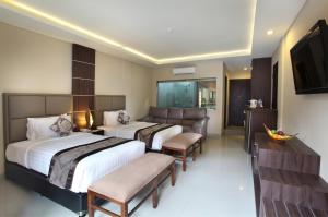 a hotel room with two beds and a television at d'Penjor Seminyak in Seminyak +23 photos
