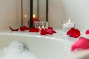 un mostrador de baño con rosas rojas y velas en The Originals City, Hôtel Armony, Dijon Sud (Inter-Hotel) en Chenôve