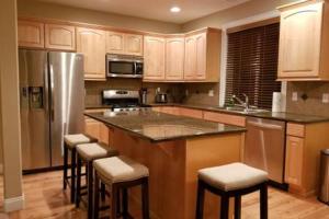 a kitchen with a large island with bar stools at JOFER Seattle/Renton Home in Renton
