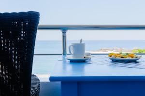 ein blauer Tisch mit einer Tasse Kaffee und Obst darauf in der Unterkunft Lefka Ori in Chora Sfakion