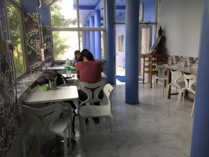 dos personas sentadas en mesas en un restaurante en Tara Guest House, en Bodh Gaya