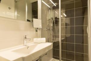 La salle de bains est pourvue d'un lavabo et d'une douche. dans l'établissement The Originals City, Hôtel Cléria, Lorient, à Lorient