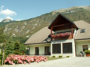 ein Haus mit Blumen vor einem Berg in der Unterkunft ISONZO APARTMENT in Bovec