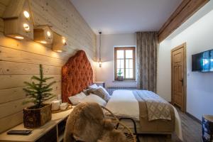 Niedźwiedzia Residence في بورونين: غرفة نوم بسرير وطاولة مع شجرة