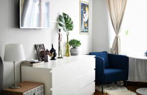 a living room with a white dresser and a blue chair at Andrea Apartments in Cluj-Napoca