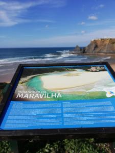 a sign in front of a beach with the ocean at Sol Mar in Odeceixe