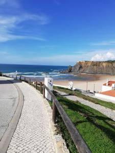a road next to a beach with the ocean at Sol Mar in Odeceixe
