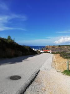 an empty road with the ocean in the background at Sol Mar in Odeceixe
