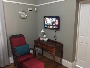 a room with a chair and a desk and a tv at Casa Mia in Pietermaritzburg