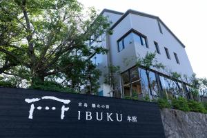 un bâtiment avec un panneau devant un bâtiment dans l'établissement 宮島離れの宿 IBUKU -Miyajima Hanare no Yado IBUKU-, à Miyajima