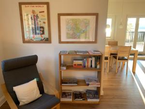 a living room with a chair and a book shelf at Potsdam-Krampnitz in Potsdam