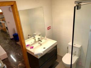 W łazience znajduje się umywalka, toaleta i lustro. w obiekcie Apartamento Conde II w Saragossie