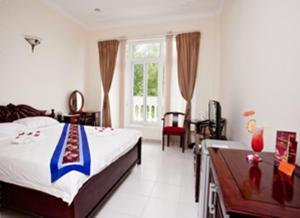 1 dormitorio con cama, mesa y ventana en Nathalie's Vung Tau Hotel, en Vung Tau