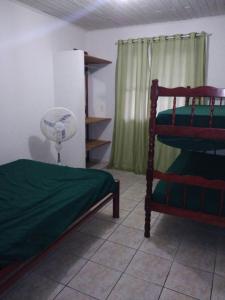 a bedroom with two bunk beds and a fan at Residência Deolindo in Itapoa