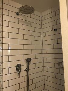 a shower with white tiled walls and a shower head at A secret Oasis in Eilat