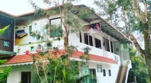 een wit huis met een rood dak bij Green Leaf Home Stay in Thekkady