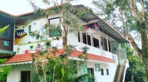 Casa blanca con techo rojo en Green Leaf Home Stay, en Thekkady