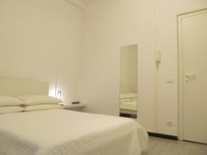 - une chambre blanche avec un lit et un miroir dans l'établissement Old Town Guest House, à Gênes