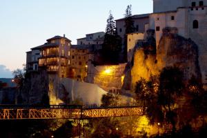 a town on a mountain with a bridge and buildings at Apartamentos Casas Colgadas in Cuenca