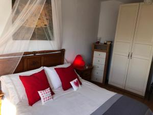 a bedroom with a bed with red and white pillows at Romantico con piscina privada solo para ti in Punta Mujeres +43 photos