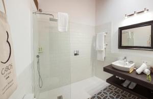 baño blanco con ducha y lavamanos en Hotel Rural 3 Cabos, en El Vallin