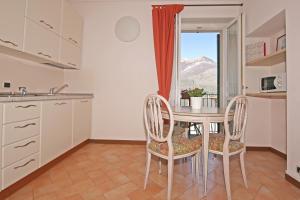 een keuken met een tafel en stoelen en een raam bij Residence la Limonera in Bellagio