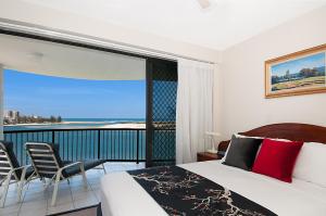 a hotel room with a bed and a chair at Windward Passage in Caloundra