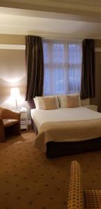 a bedroom with a large bed and a window at The Tudor Hotel in Harrow