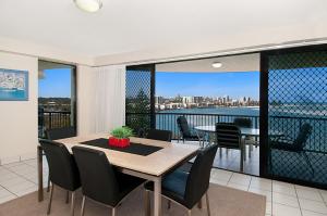 a dining room table with chairs and a window at Windward Passage in Caloundra