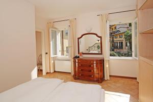 a bedroom with a bed and a mirror and a dresser at Residence la Limonera in Bellagio