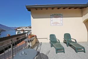 a patio with two chairs and a table on a balcony at Residence la Limonera in Bellagio
