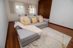 a living room with a gray couch with pillows at Casas do Paço - Philosophy Apartments in Braga