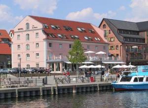
boats are docked in front of a large building at Hotel Am Yachthafen in Waren
