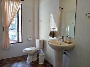 a bathroom with a toilet, sink, and mirror at Woodlawn Villas Resort SHA Plus in Ko Tao